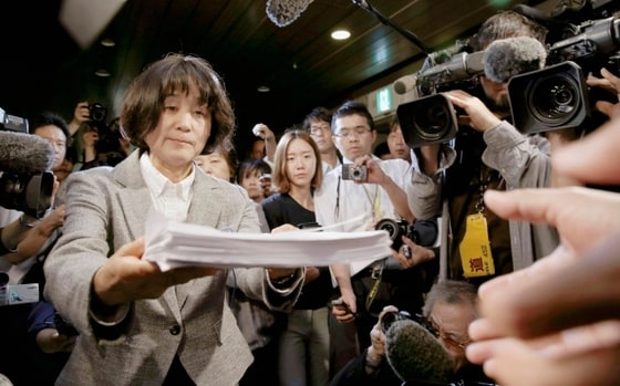 방청자 위안부 문제 공동대표가 24일 위안부 관련 망언을 일삼는 하시모토 도루 시장앞으로 보내는 항의서를 오사카시청 직원에게 전달하고 있다. 일본을 항의방문중인 위안부피해자 김복동, 길원옥 할머니는 이날 하시모토와 면담을 가질 예정이었으나 이를 취소했다. © 로이터=News1 