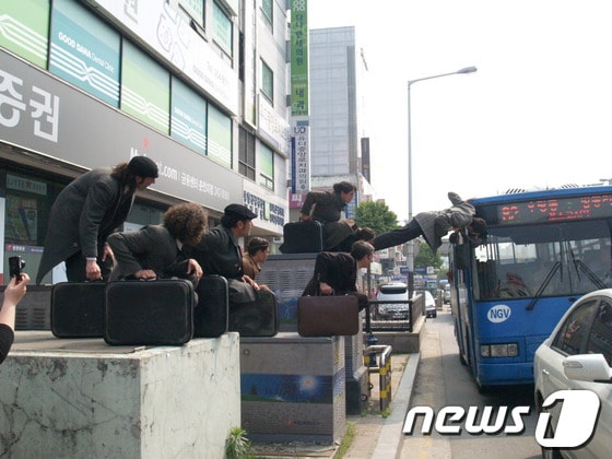 공연단이 버스에 매달려 있다 © News1 윤창완 기자