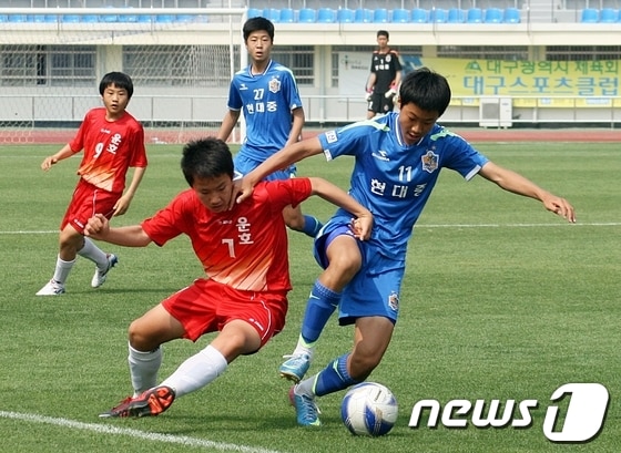 25일 대구 북구 시민운동장에서 열린 '제42회 전국소년체육대회' 축구 남중부 1회전에서 울산 현대중(파란색 유니폼)과 충북 운호중 선수들이 치열한 볼다툼을 하고 있다. 이날 경기는 울산 현대중이 5-0으로 승리했다. 2013.5.25/뉴스1 © News1 변의현 기자