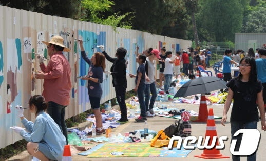 경기 시흥지역 시민사회, 학생, 자원봉사자들이 25일 오이도역사공원 울타리에  그림을 그리고 있다./사진제공=시흥시.© News1  