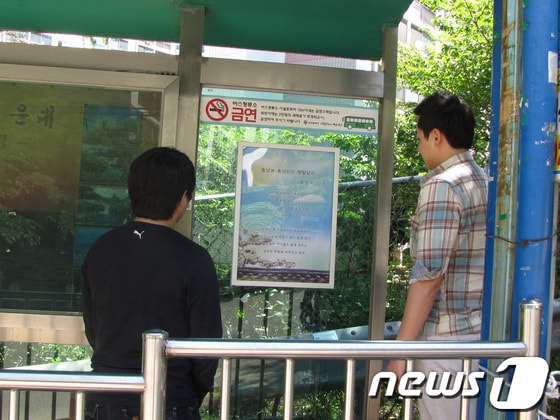 해운대구 반송2동 남흥아파트 정류장에 게시된 '시화'를 주민들이 읽고 있다.(해운대구 제공)© News1