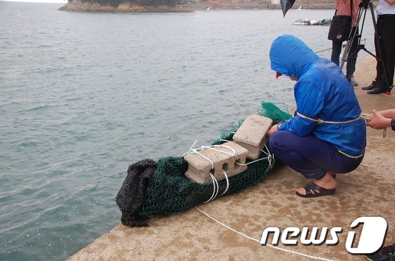 여수해양경찰서는 지난달 11일 보험금을 목적으로 여성을 살해해 유기한 혐의(살인)로 신모(34)씨와 서모(43·여)씨, 김모(42·여)씨 등 3명을 구속했다. 신씨가 이날 여수 백야대교 인근에서 현장검증을 하고 있다.(여수해양경찰서 제공)2013.6.11/뉴스1 © News1 