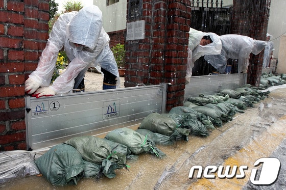 장마철 집중호우를 대비해 13일 오전 서울 서초구 양재동 주택가에서 열린 지하주택 침수 예방을 위한 차수판 설치 훈련에서 참가자들이 차수판과 모래주머니를 설치하고 있다.2013.6.13/뉴스1 © News1 이광호 기자