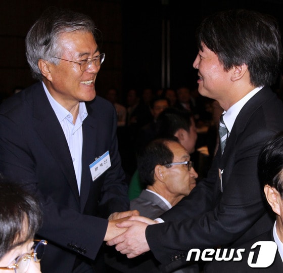 문재인 민주당 의원(왼쪽)과 안철수 무소속 의원이 지난 6월 14일 오후 서울 여의도 63빌딩 그랜드볼룸에서 열린 '6.15 남북공동선언 13주년 기념식'에서 악수를 하고 있다. 2013.6.14/뉴스1 © News1 유승관 기자