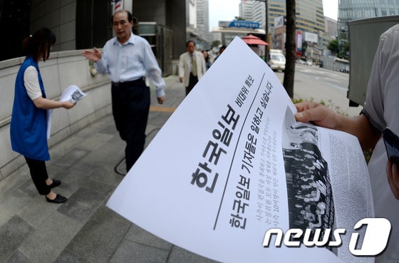 한국일보에 용역을 동원한 편집국 봉쇄와 기사 집배신시스템 폐쇄라는 한국 언론사상 초유의 사태가 발생한 가운데 지난 17일 서울 중구 남대문로 2가 본사 앞에서 전국언론노동조합 한국일보지부 기자들이 비상대책위 특보를 시민들에게 나눠주고 있다. 한국일보 노동조합 비상대책위원회에 따르면 사측은 지난 15일 오후 6시20분쯤 서울 중구 남대문로 한진빌딩 15층 편집국을 폐쇄하고 당시 편집국 안에서 근무 중이던 당직기자를 편집국 밖으로 몰아낸 후 '근로제공 확약서'라는 문서에 서명하도록 요구했다고 밝혔다. 2013.6.17/뉴스1 © News1 박정호 기자