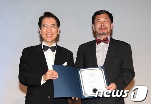 17일 저녁 서울 그랜드하얏트호텔에서 열린 세계보험협회(IIS) 연차총회 시상식에서 교보생명 신창재 회장(왼쪽)이 ‘신용호세계보험학술대상’ 수상자로 선정된 美 세인트존스대 권욱진 교수에게 상패를 수여하고 있다.© News1
