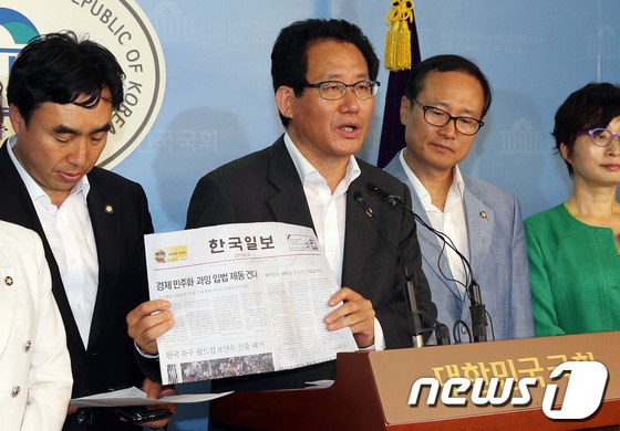 국회 교육문화관광체육위원회, 환경노동위원회 소속 민주당 의원들이 19일 오후 서울 여의도 국회 정론관에서 기자회견을 열고 한국일보 정상화를 촉구하고 있다. 유기홍 의원이 오늘자 한국일보를 들어보이고 있다. 2013.6.19/뉴스1 © News1 허경 기자