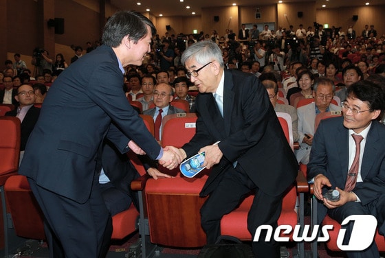 무소속 안철수 의원이 지난 6월 19일 서울 여의도 국회 의원회관에서 열린 자신의 싱크탱크 '정책네트워크 내일' 창립 기념 심포지엄에서 최장집 당시 이사장과 악수를 나누고 있다.            2013.6.19/뉴스1 © News1 오대일 기자