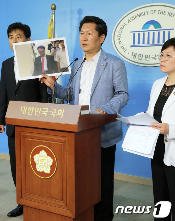 민주당 정청래 정보위원회 간사와 정보위원들이 20일 서울 여의도 국회 정론관에서 가진 기자회견에서 국가정보원 한기범 1차장이 고 노무현 전 대통령의 'NLL 대화록'을 새누리당에 건네주고 국회를 빠져나가는 모습이 담긴 사진을 공개하고 있다. 의원들은 이 자리에서 