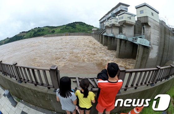 14일 경기도 연천군 군남면 군남댐에서 주민들이 물이 방류되는 모습을 바라보고 있다. 현재 임진강 홍수조절용인 군남댐 저수위가 올라가 13개의 수문을 모두 개방해 물을 방류하고 있다. 2013.7.14/뉴스1 © News1   박세연 기자