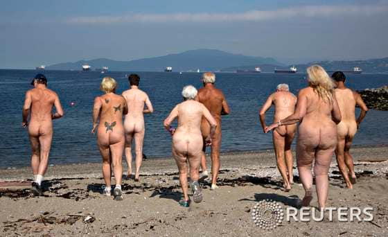 18일(현지시간) 캐나다 밴쿠버의 선셋 비치에서 나체의 남녀들이 바다를 향해 뛰어가고 있다. 이 단체는 이번 주말 열리는 '제 17회 레크비치(Wreck Beach) 누드 달리기' 를 홍보하고 있다. 레크 비치는 자연주의자들과 나체주의자들에게 인기 있는 밴쿠버의 외딴 해변이다. © 로이터=뉴스1  