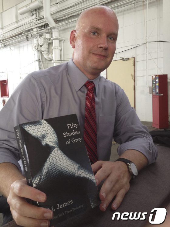 21일(현지시간) '엄마들의 포르노'로 유명한 영국 소설가 E.L. 제임스의 소설 '그레이의 50가지 비밀'을 들고 있는 제임스 코넬 변호사. 코넬은 자신의 의뢰인이자 관타나모 수용소에 수감중인 9·11테러 혐의자 아마르 알 발루치가 교도관이 건넨 이 소설이 가진 사회적인 이미지를 모른 채 법정에 들어갔다가 피해를 입었다고 주장하고 있다.© 로이터=News1 