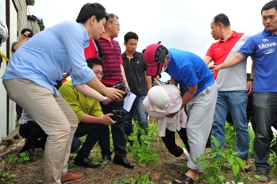 군산 실종 여성 살해 현장 검증이 실시된 3일 오후 전북 군산시 회현면 월연리 소재 폐창고에서 피의자 정모 경사가 목 졸라 살해한 피해자의 시신을 옮기는 상황을 재연하고 있다.2013.8.3/뉴스1 © News1   김대웅 기자