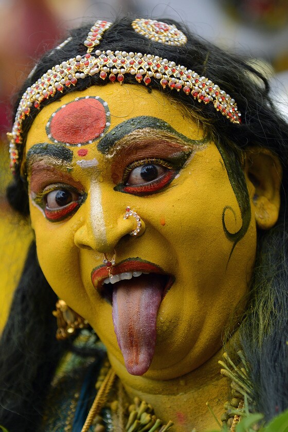 힌두교 여신 마하칼리 분장을 한 인도 예술가가 하이데라바드의 스리 아카나 마단나 마한칼리 사원에서 11일간 열리는  '보날루' 전통축제의 마지막 행진 중 무아지경에 빠져있다. 보날루는 마하칼리 여신에 대한 제사의식이다. 이 축제기간에 여성들은 마하칼리 여신에게 음식과 춤을 공물로 바친다.© AFP=뉴스1  