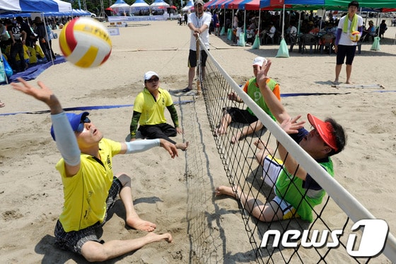 6일 오전 광안리해수욕장에서 열린 '제16회 장애인한바다축제'에서 참가 선수들이 비치발리볼 경기를 하고 있다. 이번 축제는 '파도를 넘어 희망으로'를 주제로 전국장애인비치발리볼대회, 한바다 물놀이, 팔씨름대회, 닭싸움대회, 투호, 해변노래자랑, 페이스페인팅 등이 펼쳐진다. 2013.8.6/뉴스1 © News1 전혜원 기자