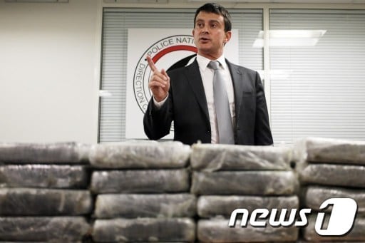 21일(현지시간) 마뉘엘 발스 프랑스 내무장관이 카라카스발 파리행 에어 프랑스에서 적발한 코카인 1.3톤을 담았던 30개의 가방을 공개하며 기자회견을 열고 있다. © AFP=뉴스1  