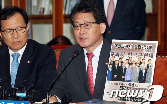 유기홍 민주당 역사교과서 친일미화 왜곡대책위원회 위원장이 26일 오전 서울 여의도 국회에서 열린 24시 비상국회 운영본부회의에서 박근혜 대통령이 2008년에 대안교과서 출판기념회 참석한 사진을 들어보이며 발언하고 있다. 2013.9.26/뉴스1 © News1   허경 기자