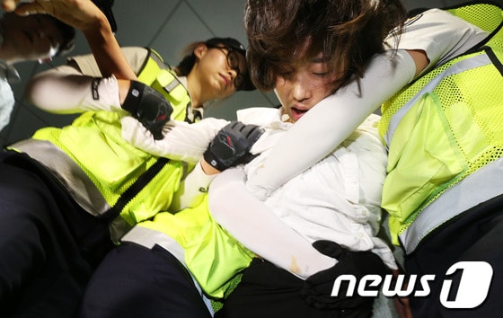 통합진보당 김재연 의원이 4일 저녁 국회 의원회관에서 이석기 의원 강제구인에 나선 국정원 직원들과 대치하다 여경들에 의해 끌려나오고 있다. 2013.9.4/뉴스1 © News1   오대일 기자