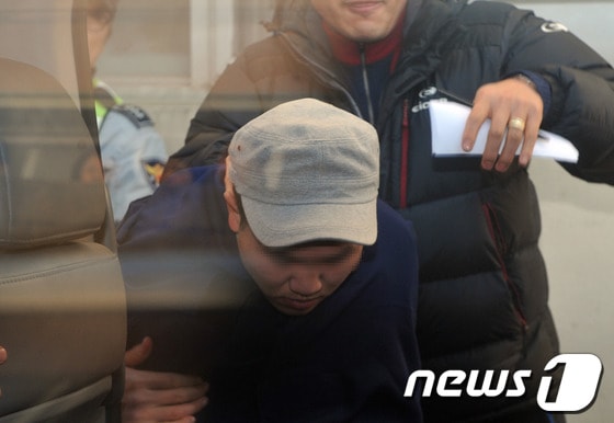 평소 자신을 무시한다는 이유로 고종사촌 동생을 전기톱으로 살해한 이모(25)씨가 23일 오후 울산시 남구 자신의 아파트에서 현장검증을 마치고 경찰 이송차로 오르고 있다.  이씨는 지난 19일 고종사촌 동생 김모(23)씨를 자신의 아파트로 불러들여 수면제를 먹인 뒤 전기톱을 휘둘러 무참히 살해한 혐의를 받고 있다. 2014.1.23/뉴스1 © News1   노화정  기자