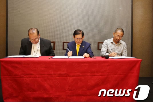 지난달 25일 필리핀 제너럴 산토스市의 한 호텔에서 이만희 ‘하늘문화세계평화광복 평화사절단’ 대표(가운데)와 페르난도 카펠라 민다나오 다바오 前 대주교, 이스마엘 망구다다투 민다나오 이슬람 자치구 마귄다나오 주지사가 전쟁종식·세계평화 협약서에 서명하고 있다./ 사진제공=하늘문화세계평화광복 평화사절단© News1  