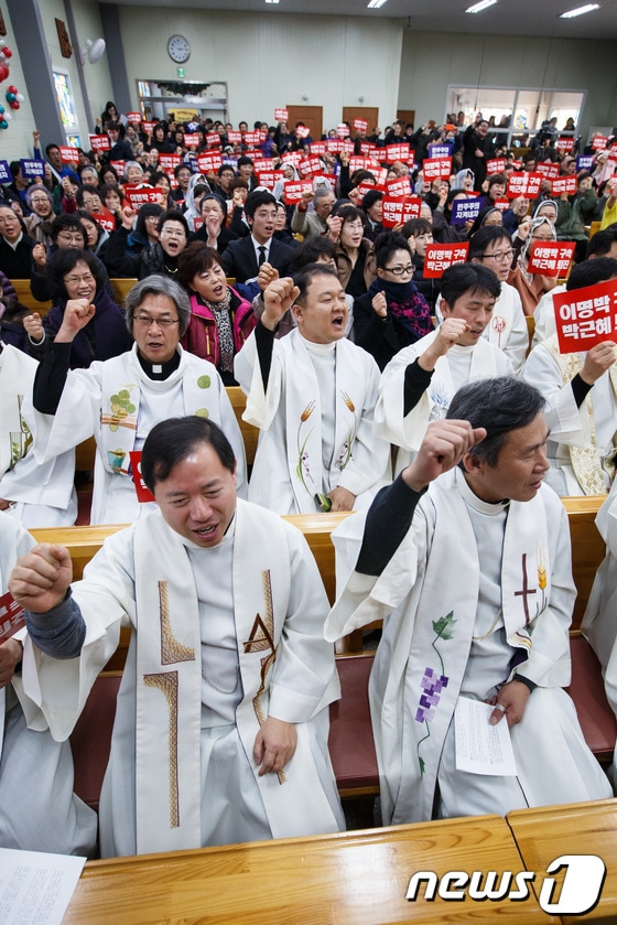 6일 오후 경기 화성시 기산성당에서 열린 천주교정의구현사제단 수원교구 주최 관권 부정선거 진상규명 및 박근혜 정권의 회개와 퇴진을 촉구하는 시국미사에서 참석자들이 '이명박 구속' '박근혜 퇴진' '민주주의 지켜내자라' 쓰여진 손팻말을 들고 구호를 외치고 있다. 2014. 1. 6/뉴스1 유승관 기자 © News1 
