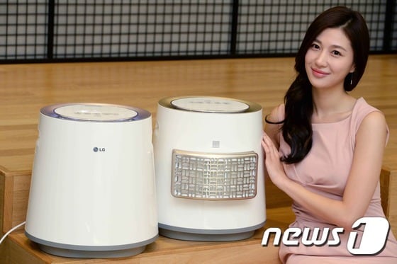 여성 모델이 12일 서울 여의도 LG트윈빌딩에서 위생기능을 강화한 LG 에어워셔 신제품을 소개하고 있다. "LG 에어워셔"는 에어워셔 기능에 공기청정기능까지 구현한다. 초미세먼지보다 125배 작은 0.02㎛(마이크로미터) 크기의 먼지까지 제거하는 ‘초미세먼지 필터’와 냄새/일산화탄소 등 유해 가스를 제거하는 ‘탈취필터’로 구성된 ‘집중청정키트’를 제공해 소비자가 필요에 따라 제품의 공기 흡입구에 탈부착할 수 있다. (LG전자 제공) 2014.10.12/뉴스1 ⓒ News1