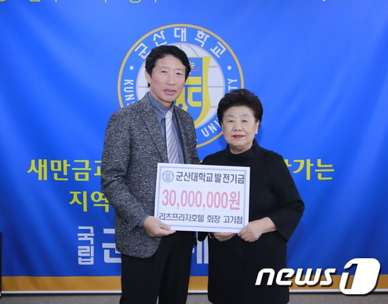 고기점 군산리츠프라자호텔 대표(오른쪽)가 나의균 군산대 총장에게 대학발전기금을 전달하고 있다. ⓒ News1