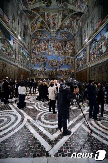 바티칸을 출입하는 언론인들이 29일(현지시간) 로마 시스티나성당 내부에 새로 장식된 LED(발광다이오드) 조명시설을 둘러보고 있다. @AFP=News1