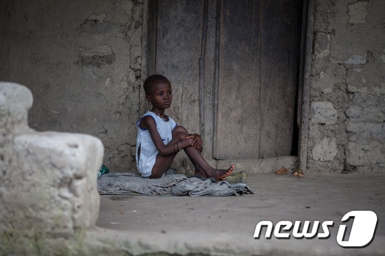 6일(현지시간) 에볼라 바이러스 감염이 의심되는 한 시에라리온 소녀가 병원 한쪽 구석에 격리된 채 앉아 있다.ⓒ AFP=뉴스1