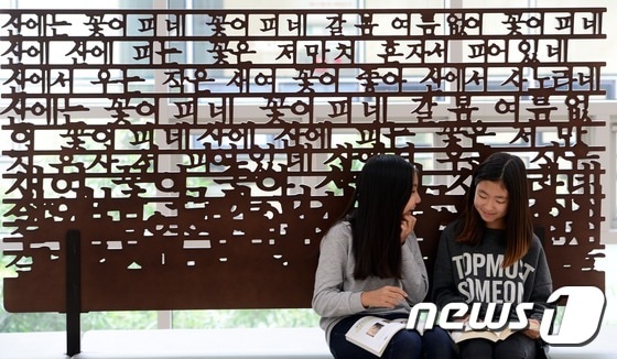 한글날을 하루 앞둔 8일 오후 서울 용산구 국립한글박물관에서 학생들이 한글 모양의 조형물 앞에서 책을 읽고 있다. 2014.10.8/뉴스1 ⓒ News1 양동욱 기자