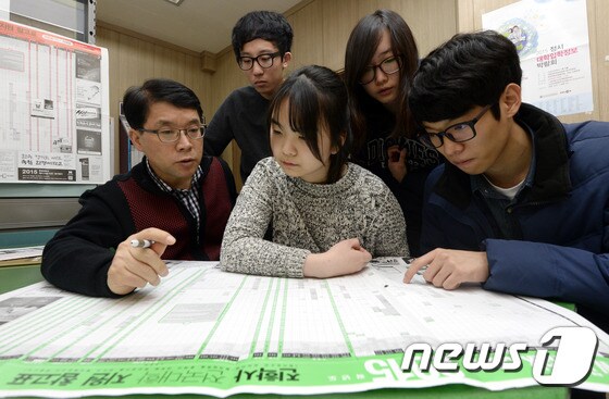2015학년도 대학수학능력시험에서 생명과학Ⅱ 8번과 영어 25번 문항이 복수정답 처리되면서 입시 지형 일대에 변화가 예상되는 가운데 25일 서울의 한 고등학교에서 고3 부장 선생님과 수험생들이 배치표를 살펴보고 있다. 2014.11.25/뉴스1 ⓒ News1 