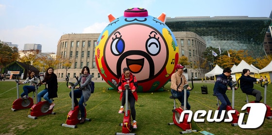 6일 오후 서울광장에서 열린 높이 8m 돼지 형상 공공미술 '미스터 기부로' 설치 퍼포먼스에 참여한 시민 아티스트들이 자전거로 공기를 주입하고 있다.  ⓒ News1 박정호 기자