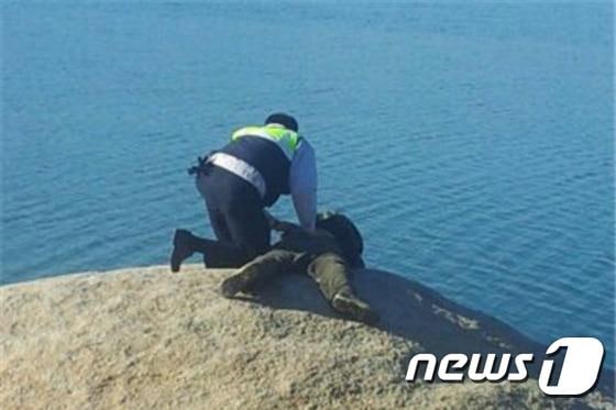 9일 오후 1시27분께 신고를 받은 경찰관이 속초시 영랑호수로 기어들어가려던 자살기도자를 제지하는 모습.(사진제공=속초경찰서) 2014.12.9/뉴스1 2014.12.09/뉴스1 ⓒ News1 엄용주 기자
