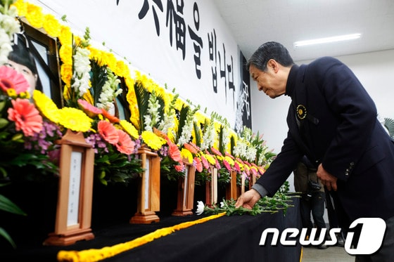 경주 마우나리조트 붕괴사고로 숨진 희생자들의 분향소가 설치된 부산외국어대학교에서 18일 정해린 부산외대 총장이 헌화하고 있다.17일 밤 9시15분경 경주 마우나리조트에서 부산외국어대학교 신입생환영회 및 오리엔테이션 중 건물 지붕이 눈의 무게를 이기지 못하고 붕괴하는 사고로 신입생 9명과 이벤트 회사 직원1명이 사망했다.2014.2.18/뉴스1 © News1 여주연 기자