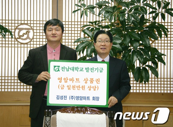 ㈜영암마트 김성진 회장(왼쪽)이 12일 오후 전남대 총장실에서 지병문 총장에게 상품권 1000 만원 상당의 발전기금을 전달하고 있다./사진제공=전남대.© News1