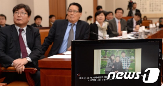 이춘석, 박지원, 신경민 민주당 의원 서기호 정의당 의원 등 법사위 야당 의원들이 19일 오후 서울 여의도 국회에서 유우성 간첩사건 증거조작 유혹과 관련해 열린 법사위 전체회의에서 신경민 의원이 공개한 유우성 첫 재판 요약본 중 가족사진을 보고 있다. 2014.3.19/뉴스1 © News1   박세연 기자