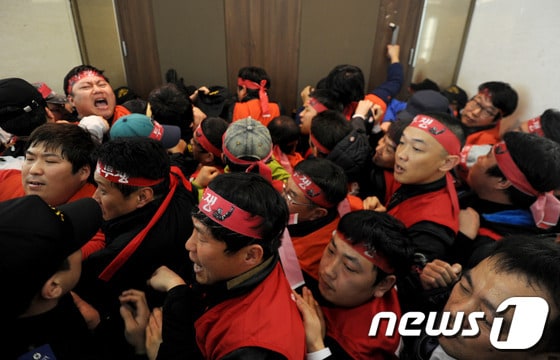 폐광지역 개발지원에 관한 특별법 재정립 및 강원랜드 바로세우기 투쟁위원회(이하 투쟁위)가 21일 오후 강원도 정선군 강원랜드 컨벤션홀 입구에서 강원랜드 이사회를 저지하며 보안요원들과 몸싸움을 하고 있다. 2014.3.21/뉴스1 © News1 윤창완 기자