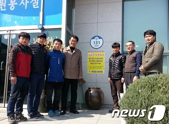 곡성군 곡성읍사무소 앞에 놓여있는 나눔의 쌀 항아리 앞에서 곡성읍청년회원이 기념촬영을 갖고있다.2014.3.24/뉴스1(사진제공=곡성군) © News1 서순규 기자