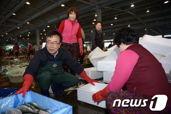 새누리당 부산시장 경선에 나선 서병수 의원이 27일 부산공동어시장을 찾아 상인들의 작업을 거들고 있다. 2014.3.27/뉴스1 © News1 여주연 기자