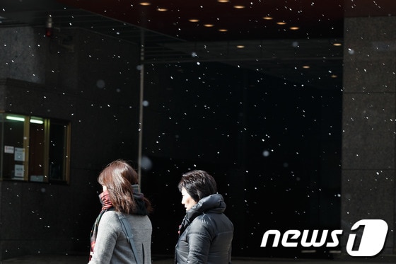 절기상 겨우내 움츠렸던 만물이 깨어난다는 경칩(驚蟄)이지만 꽃샘추위가 기승을 부린 6일 오후 시민들이 눈발이 날리는 서울 명동거리를 지나고 있다.기상청은 강원 중북부산간에는 한파특보가 발효 중인 가운데 내일까지 일교차가 큰 꽃샘추위가 이어질 것으로 내다봤다. 2014.3.6/뉴스1 © News1 유승관 기자