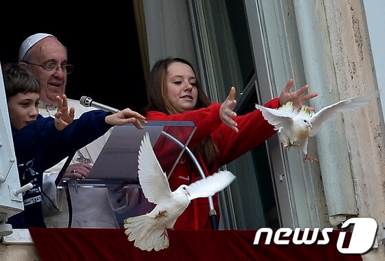 바티칸 교황청 건물에서 어린이들과 함께 비둘기를 날리고 있는 프란치스코 교황.© AFP=News1 이준규 기자