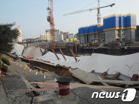 2일 오후 1시57분께 목포시 산정동 신안비치아파트 3차 주차장과 주변 도로가 갑자기 꺼졌다. 침하 규모는 폭 10m, 길이 60m, 깊이 1~7m 가량으로 목포시는 파악했다. 당시 사고로 주민 1명이 경상을 입고 주차장의 차량 1대가 매몰됐다. 경찰과 시는 아파트와 거의 맞닿은 지점에서 이뤄지는 아파트 신축공사와 침하의 연관성을 파악하고 있다. 2014.4.2/뉴스1 © News1 박준배 기자