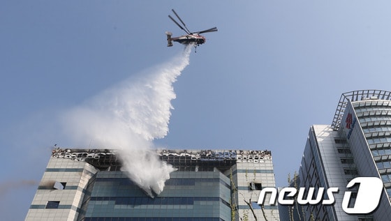 20일 오후 12시 쯤 경기 과천시 삼성SDS 과천센터에서 불이나 소방대원들이 헬기와 소방차를 동원해 불을 진압하고 있다.이날 불은 과천 삼성SDS 건물 3층 발전기 실에서 발생해 외부로 번졌으며, 건물 내부에 있는 데이터 보관장비의 상당부분을 태우고 진화됐다. 특히 소방당국이 진화를 위해 뿌린 물로 삼성SDS 대규모 장비가 침수돼 고장이 났다. 소방당국은 경찰,시청 등 인원 67명과 소방헬기 등 장비 28대를 동원해 긴급진화에 나섰다. 삼성SDS측은 “과천센터는 백업데이터를 보관하는 곳으로 메인센터는 수원에 있다”며“데이터 유실은 없는 것으로 보인다”고 말했다.2014.4.20/뉴스1  © News1   송원영 기자