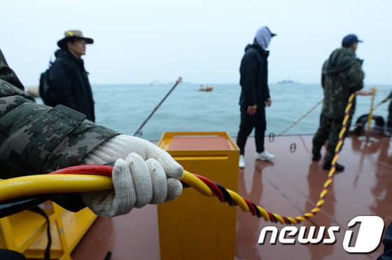 세월호 침몰사고 29일째인 14일 오후 전남 진도군 관매도 인근 사고 해역에서 해군이 실종자 수색작업 중인 잠수사의 공기 호스를 붙잡고 있다. 2014.5.14/뉴스1 © News1 박지혜 기자