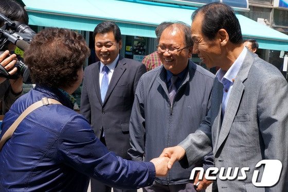 최문순 강원도지사 후보(오른쪽)와 고춘석 홍천군수 후보(왼쪽), 김재근 홍천군의원 후보(가운데)가 16일 오전 강원 홍천군 중앙시장 5일장을 방문, 지역민과 인사를 나누며 웃음을 짓고 있다. 2014.5.16/뉴스1 © News1   윤창완 기자