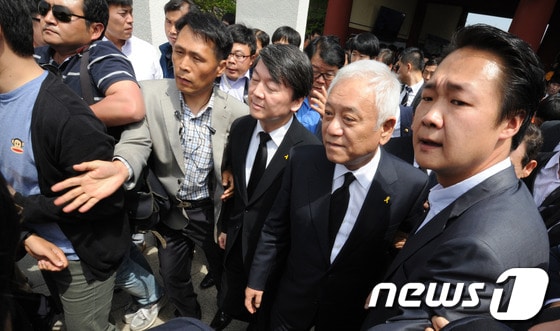 새정치민주연합 안철수, 김한길 대표가 17일 광주광역시 북구 운정동 국립 5.18민주묘지에 입장하고 있다.일부 시민들이 &#39;광주시장 낙하산 공천반대&#39; 목소리를 외치자 두 대표 주위를 당원들이 둘러싸고 있다. 2014.5.17/뉴스1  © News1   김태성 기자