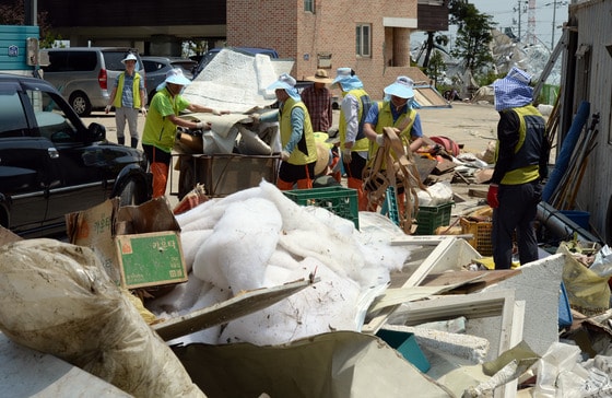 '토네이도' 피해를 입은 경기 고양시 일산서구 구산동 일원에서 11일 오후 봉사활동에 나선 농협하나로클럽 관계자들이 바람에 날아온 온실시설물을 수거하고 있다. 기상청은 10일 오후 7시께 고양시 장월나들목 인근 한강 둔치에서 토네이도 현상이 발생해 한시간 동안 지속됐다고 밝혔다. 이번 토네이도로 구산동 일원 장미 재배용 비닐하우스 등 원예시설물 20동 이상이 파손되는 피해를 입었다. 2014.6.11/뉴스1 © News1   