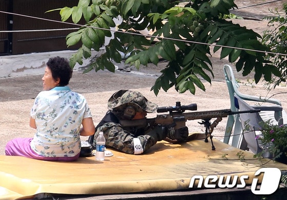23일 강원도 고성군 현내면 마차진리 마을에서 육군 저격수가 인근 야산에서 군병력과 대치 중인 무장 탈영병 임모 병장을 조준하고 있다.강원도 고성 22사단 GOP에서 총기를 난사한 후 무장탈영한 임모 병장(23)은 이날 오후 2시55분께 군 병력과 대치하던 중 자살을 시도했다. 2014.6.23/뉴스1 © News1   한재호 기자