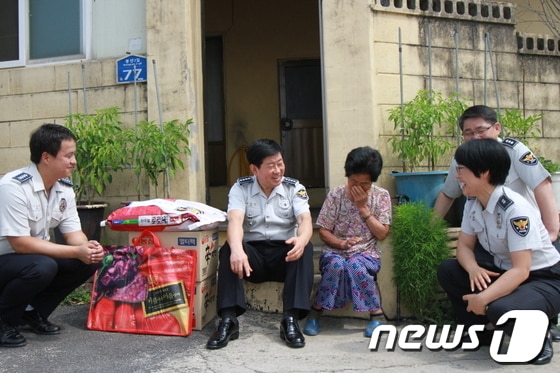 위강석 원주경찰서장(왼쪽에서 두번째)이 7일 열린 서장 취임식 당시 받은 축하 화분을 되팔아 마련한 돈으로 생필품을 구매해 지역 노인들에게 전달하고 경찰서 직원들과 함께 이야기를 나누고 있다.(사진제공=원주경찰서).2014.7.14/뉴스1 © News1 권혜민