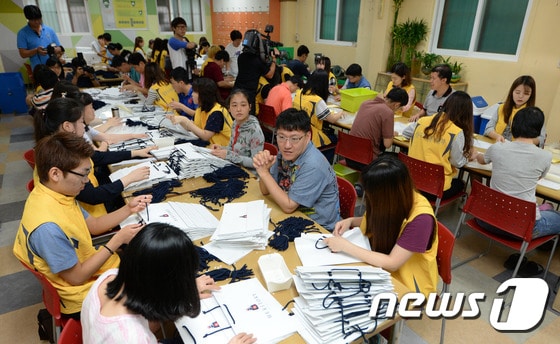 여름방학을 맞아 성동구청에서 아르바이트를 하고 있는 대학생들이 24일 오전 서울 성동구 금호동 성모보호작업장에서 발달장애를 앓고 있는 장애인들의 직업재활훈련을 돕고 있다.2014.7.24/뉴스1 ⓒ News1 민경석